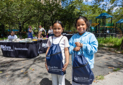 two young girls holding bags with books