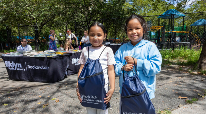 two young girls holding bags with books