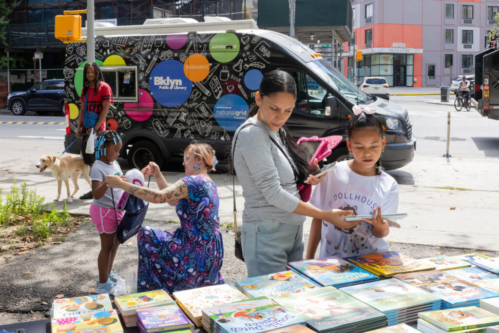 woman and children looking at books