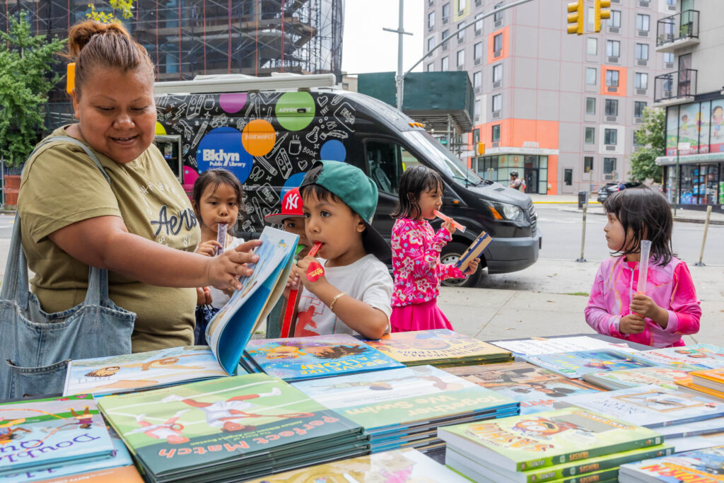 woman and children looking at books