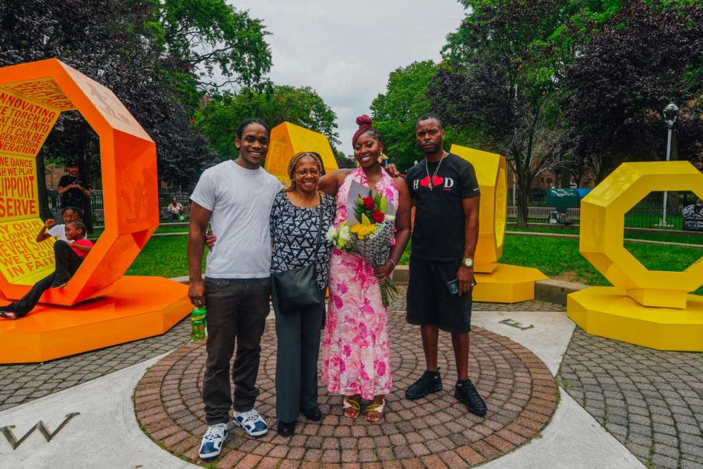 four people in front of art installation
