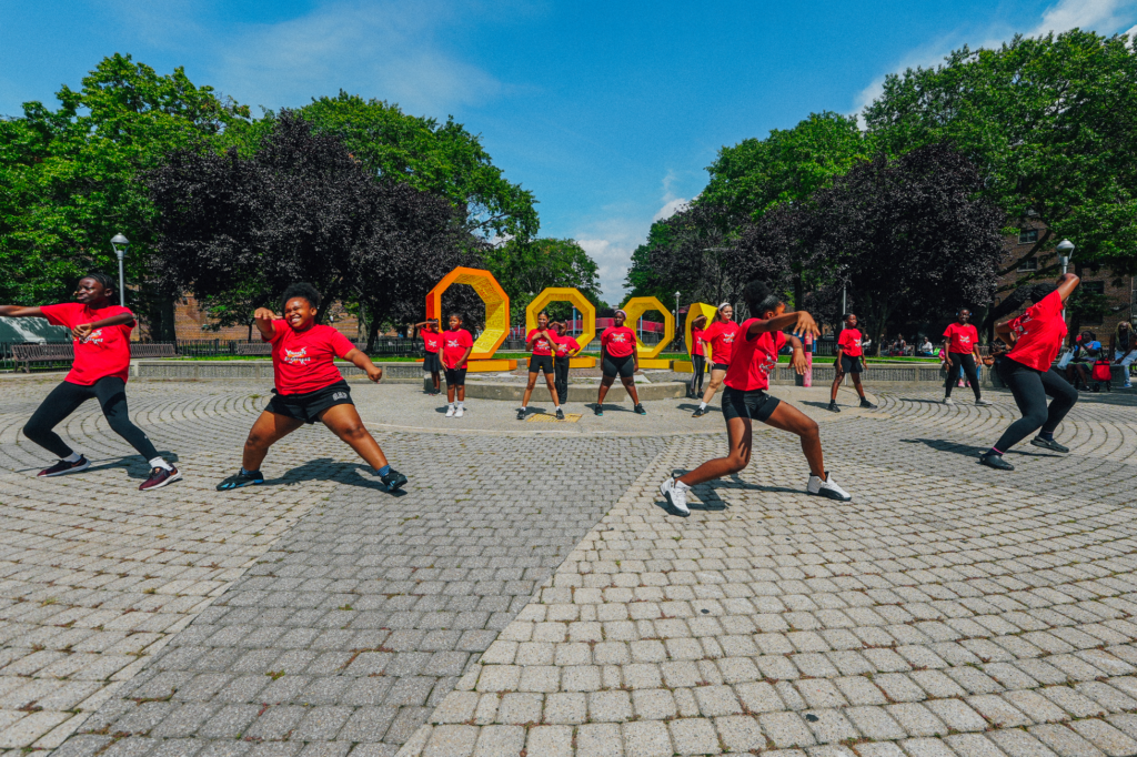 young people dancing in front of art installation