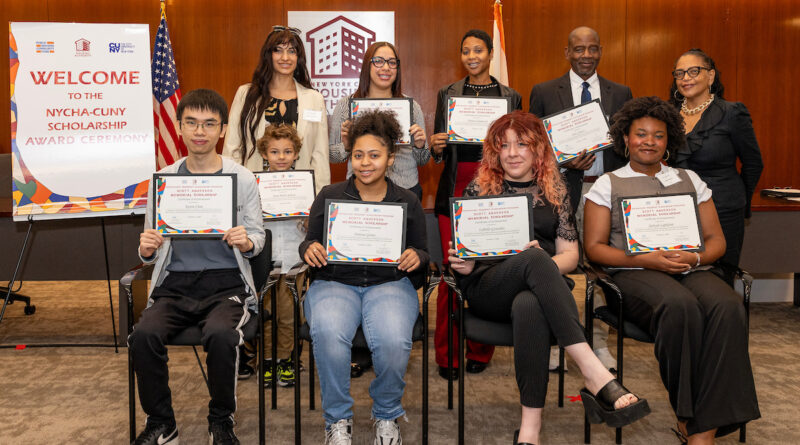A group of individuals, including youth and adults, pose together at a scholarship award ceremony, holding certificates and standing in front of a welcome banner.