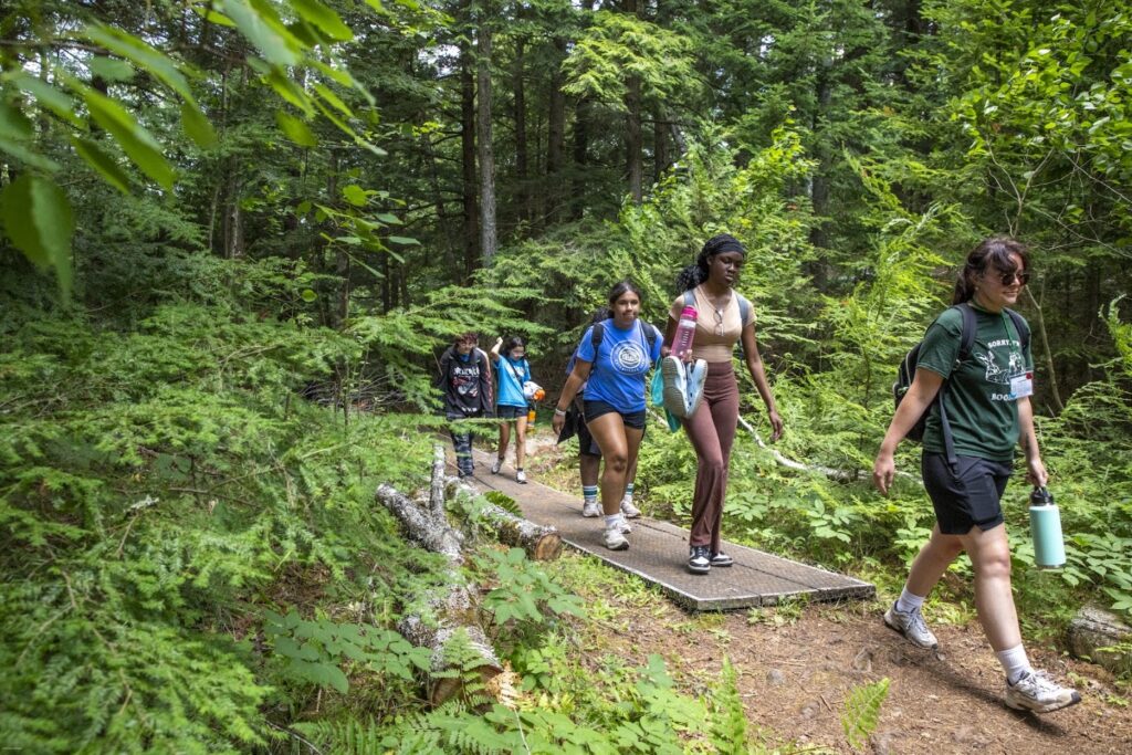 girls walking on a trail in the woods