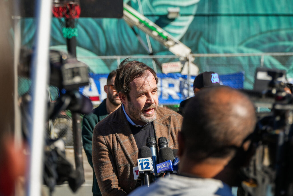 a man speaks into microphones