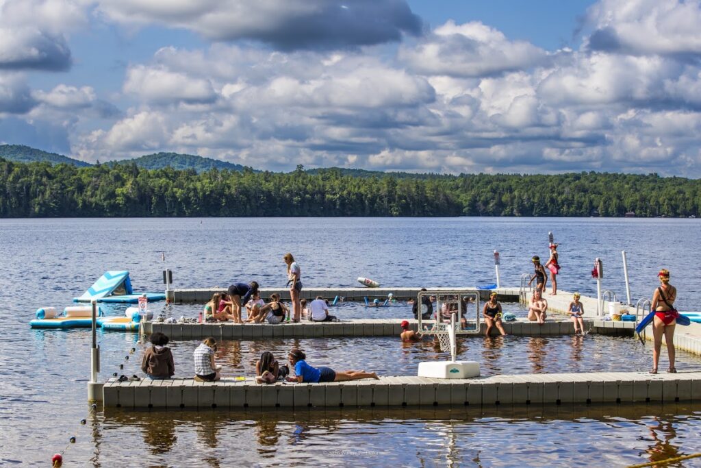 Girls in the water and on the docks at a lake