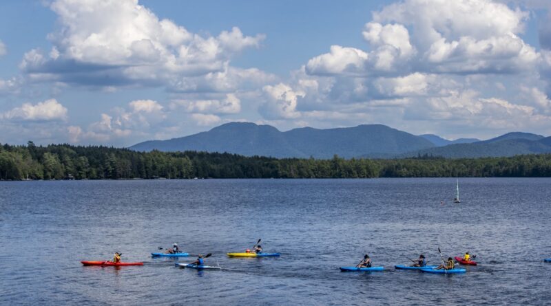 girls boating in canoes on a lake