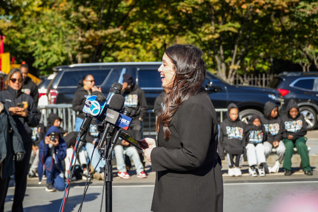 a woman speaks into microphones