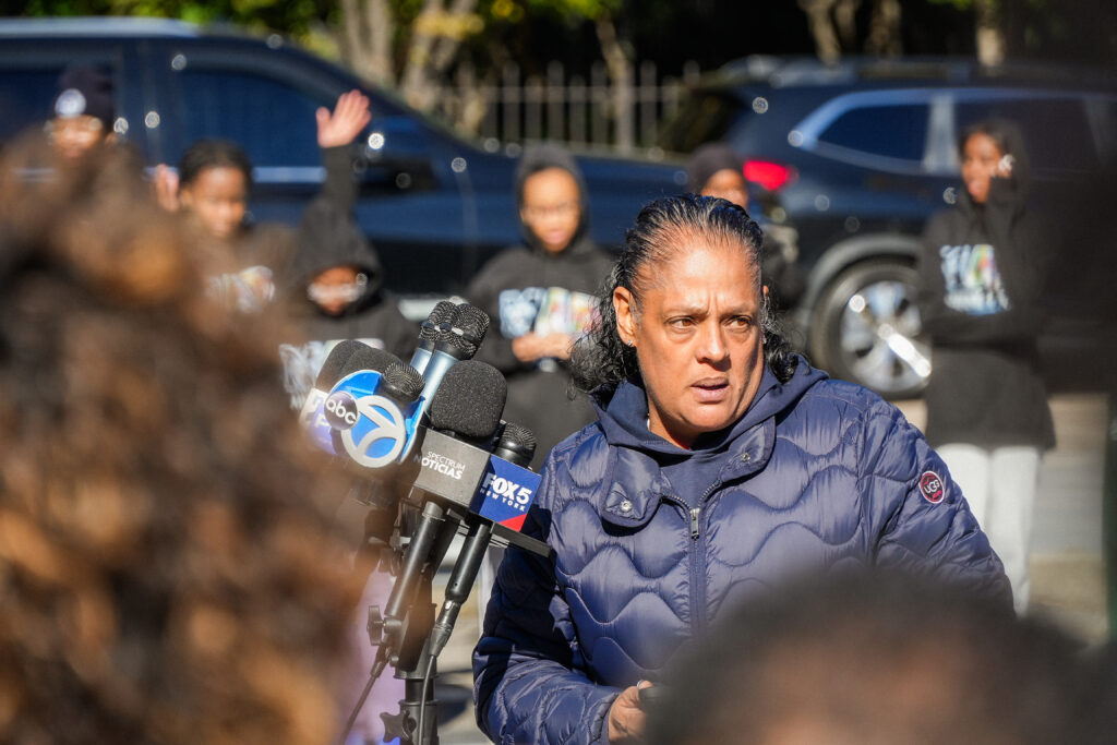 a woman speaks into microphones