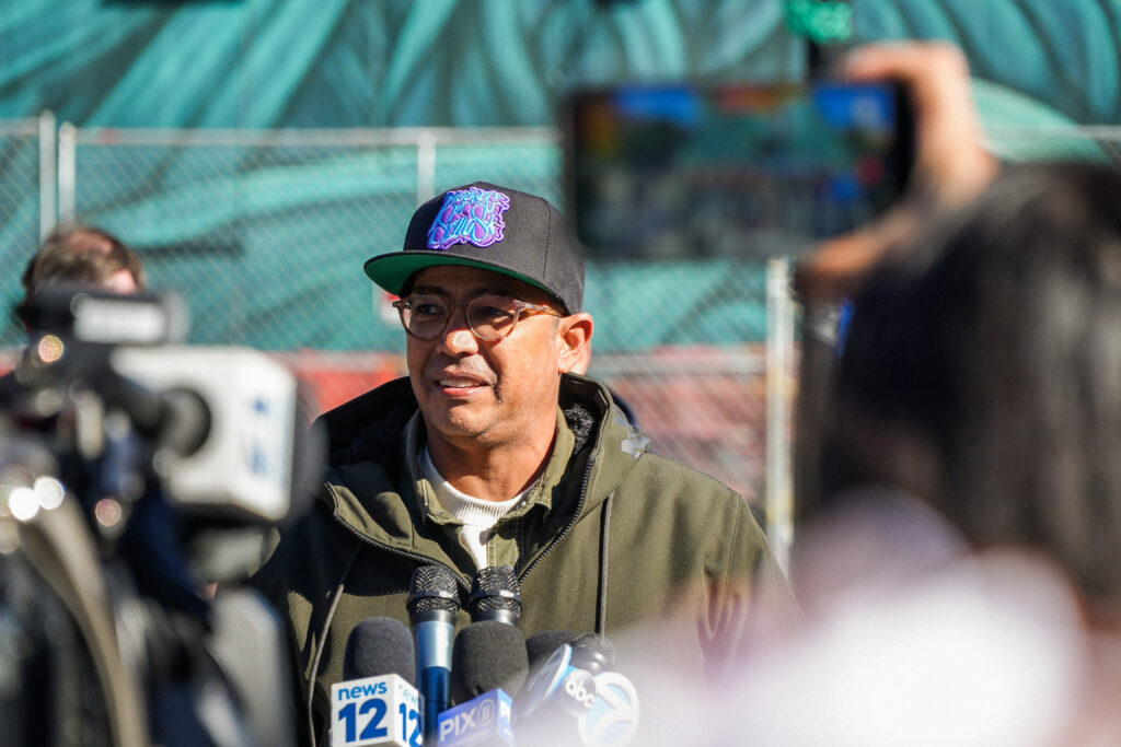 a man speaks into microphones