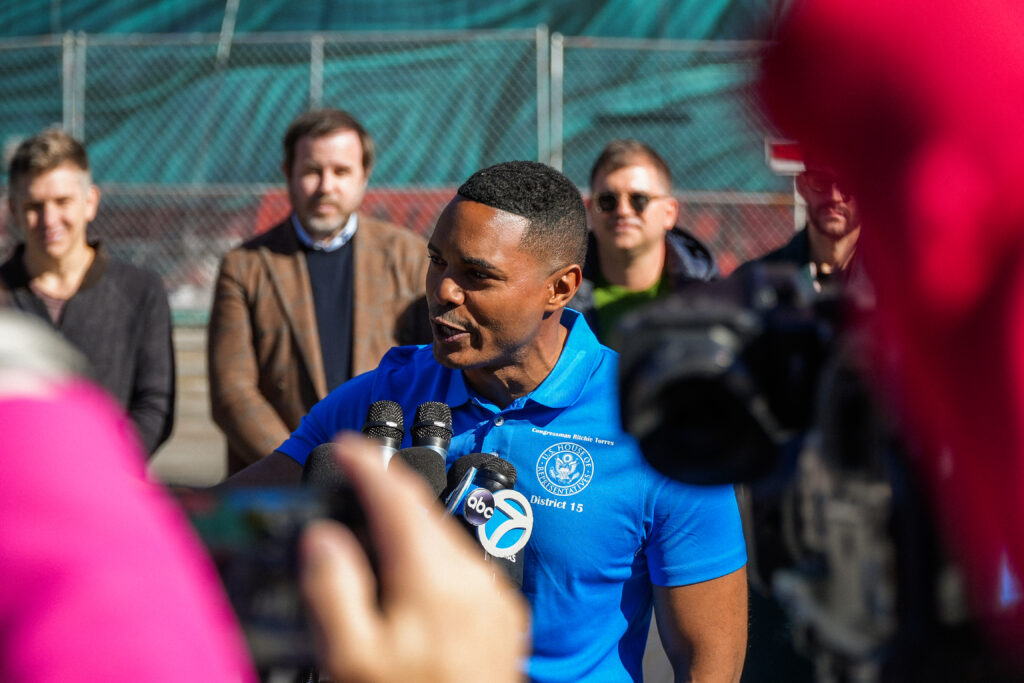 a man speaks into microphones