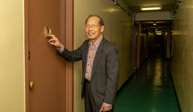 Floor Captain Fai Chan knocks on a resident's apartment door. Floor Captain Fai Chan knocks on a resident's apartment door.