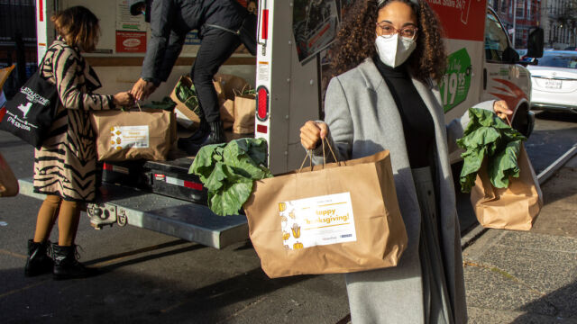 Claremont Consolidation turkeys, bags of produce and food vouchers to senior residents woman unloads bags of groceries off truck