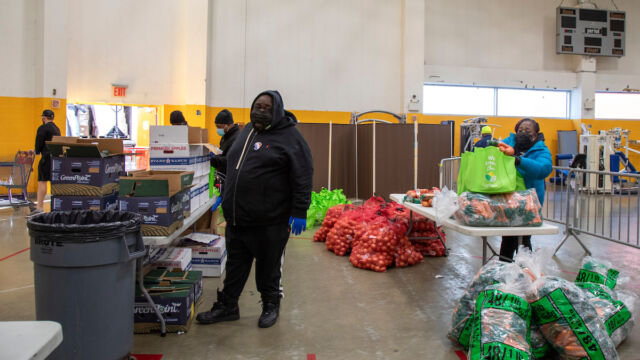 Turkey and produce giveaway at Melrose Classic Community Center. people inside room with bags of vegetables