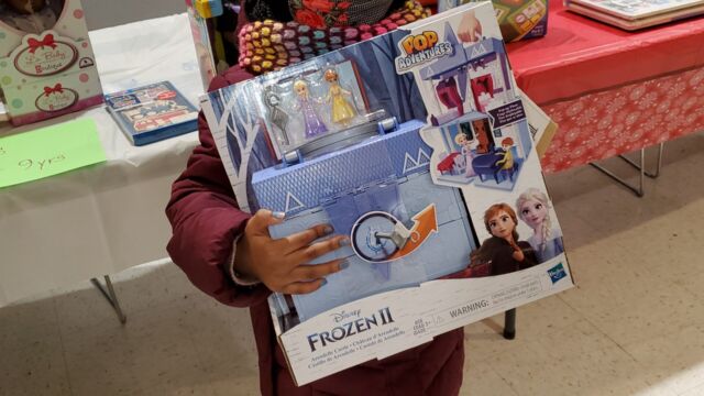 A child holds a toy received at a toy giveaway held by the Van Dyke Houses Resident Association on Christmas Eve.