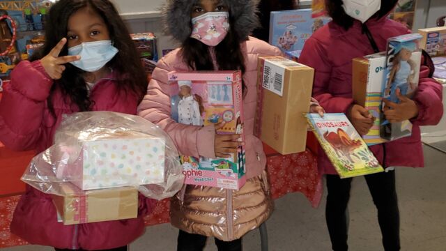 Children hold toys they received at a toy giveaway held by Van Dyke Houses Resident Association on Christmas Eve.