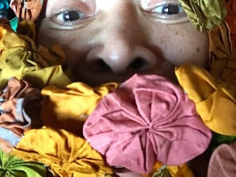 Photo by Shirley Mitchell. woman with colorful cloth flowers