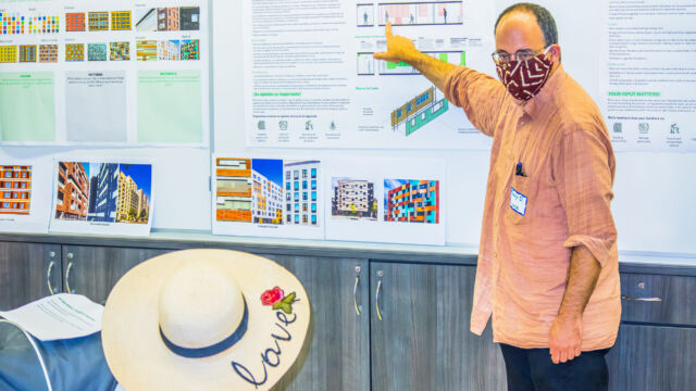 man pointing at large poster