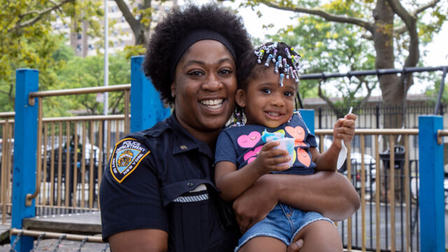 National Night Out at Linden Park woman police officer holding a young child
