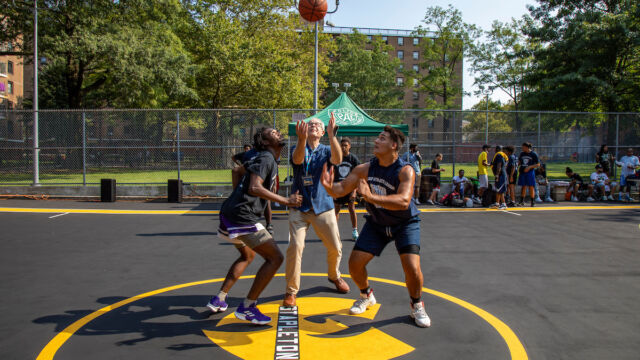 NYCHA Chair Greg Russ tosses the jump ball for a pickup game. Chair Russ tosses jump ball
