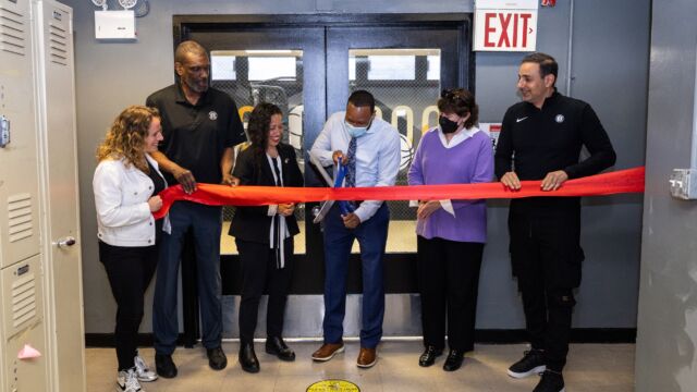 Roland Knight, Senior Program Director for the Miccio Community Center, cuts the ribbon to unveil the upgraded workout room.