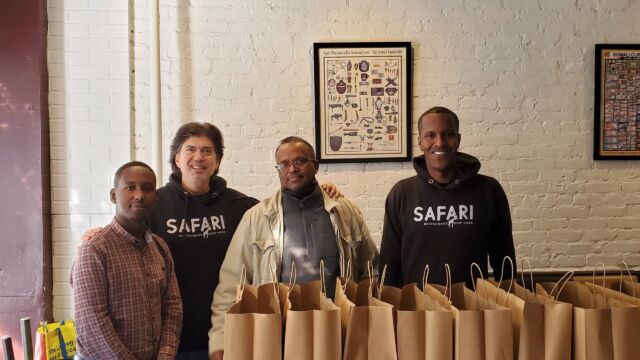 four men standing in front of paper bags